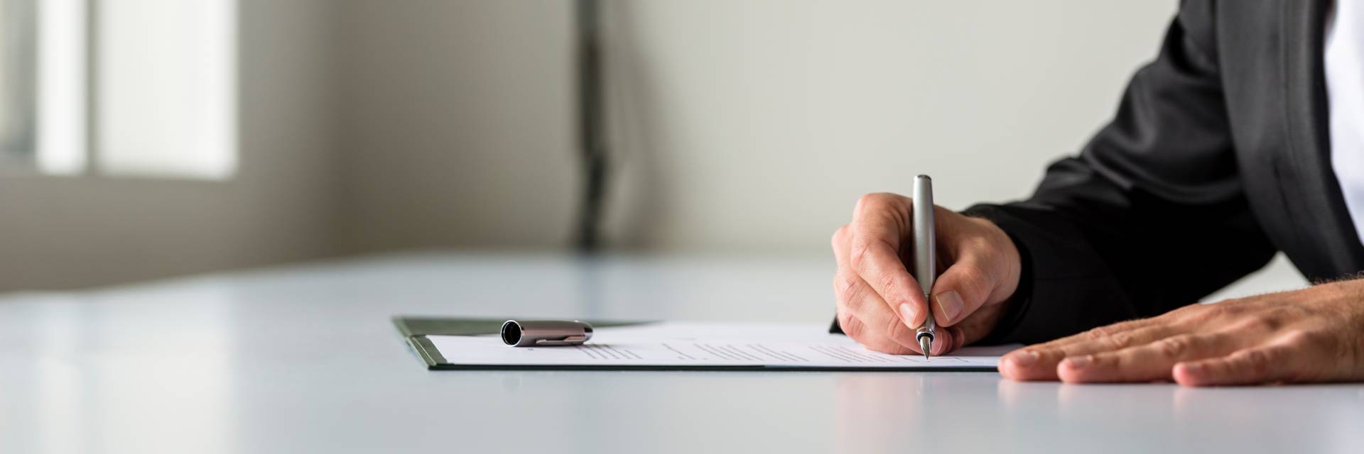 A business person signing a document,