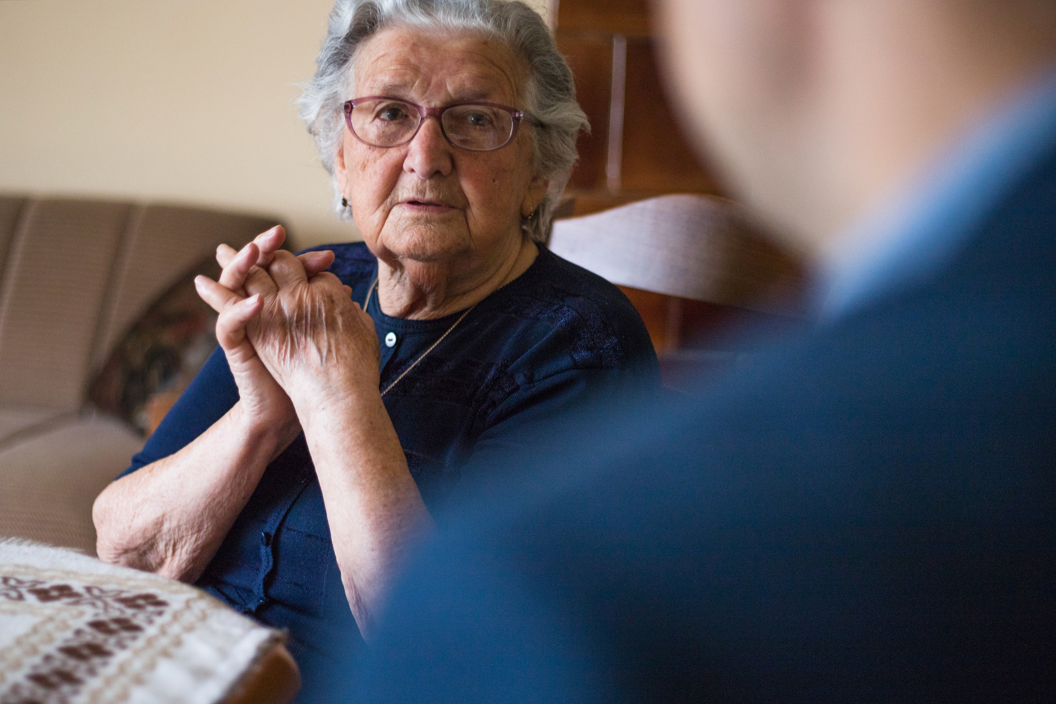 A younger main visiting his elderly mother in a retirement home catch up on how life is going.