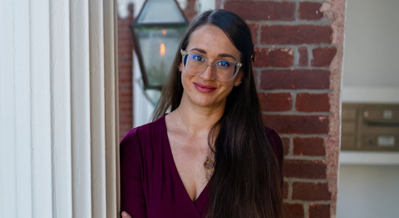 A professional headshot of Chelsea Gallivan, a woman with long dark hair and glasses, wearing a maroon v-neck shirt.