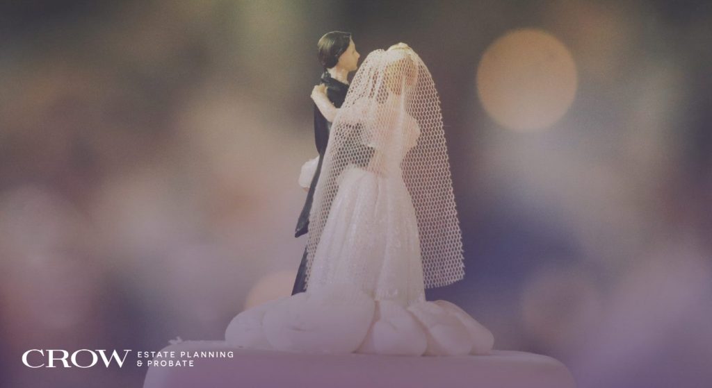 A photo of a bride and groom figurine atop a wedding cake.